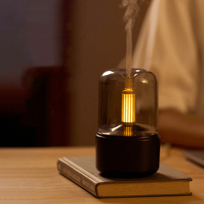 Eluna LumiFlame™ zwarte aromadiffuser met warm amber licht en fijne mist op houten tafel
