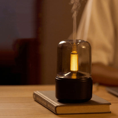 Eluna LumiFlame™ zwarte aromadiffuser met warm amber licht en fijne mist op houten tafel